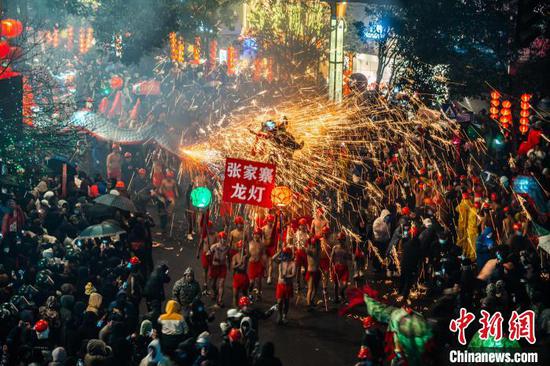 圖為舞龍者舉著龍燈接受沿街民眾噓花的“洗禮”。吳大平 攝