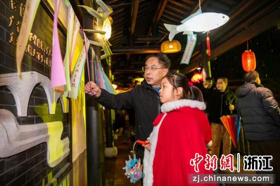 小朋友在秀溪水街的長(zhǎng)廊里猜燈謎 沈勇強(qiáng) 攝