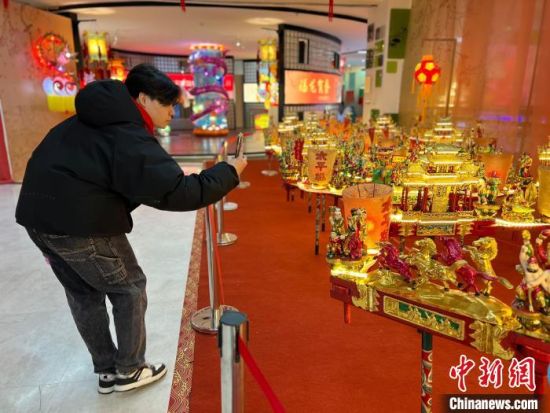 在秦淮·非遺館中，臺(tái)灣青年錢志璿拿手機(jī)拍攝浙江樂清的巨型龍燈。　中新網(wǎng)記者 朱曉穎 攝